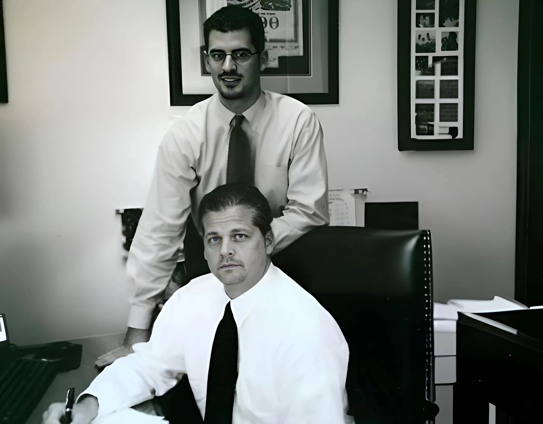 Early black-and-white photo of the Burrows Financial founding partners at their desk